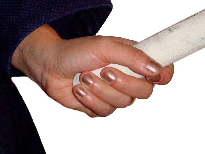 Close up of left hand correctly holding the shinai handle at the very bottom. Nails are painted a pearly pink.